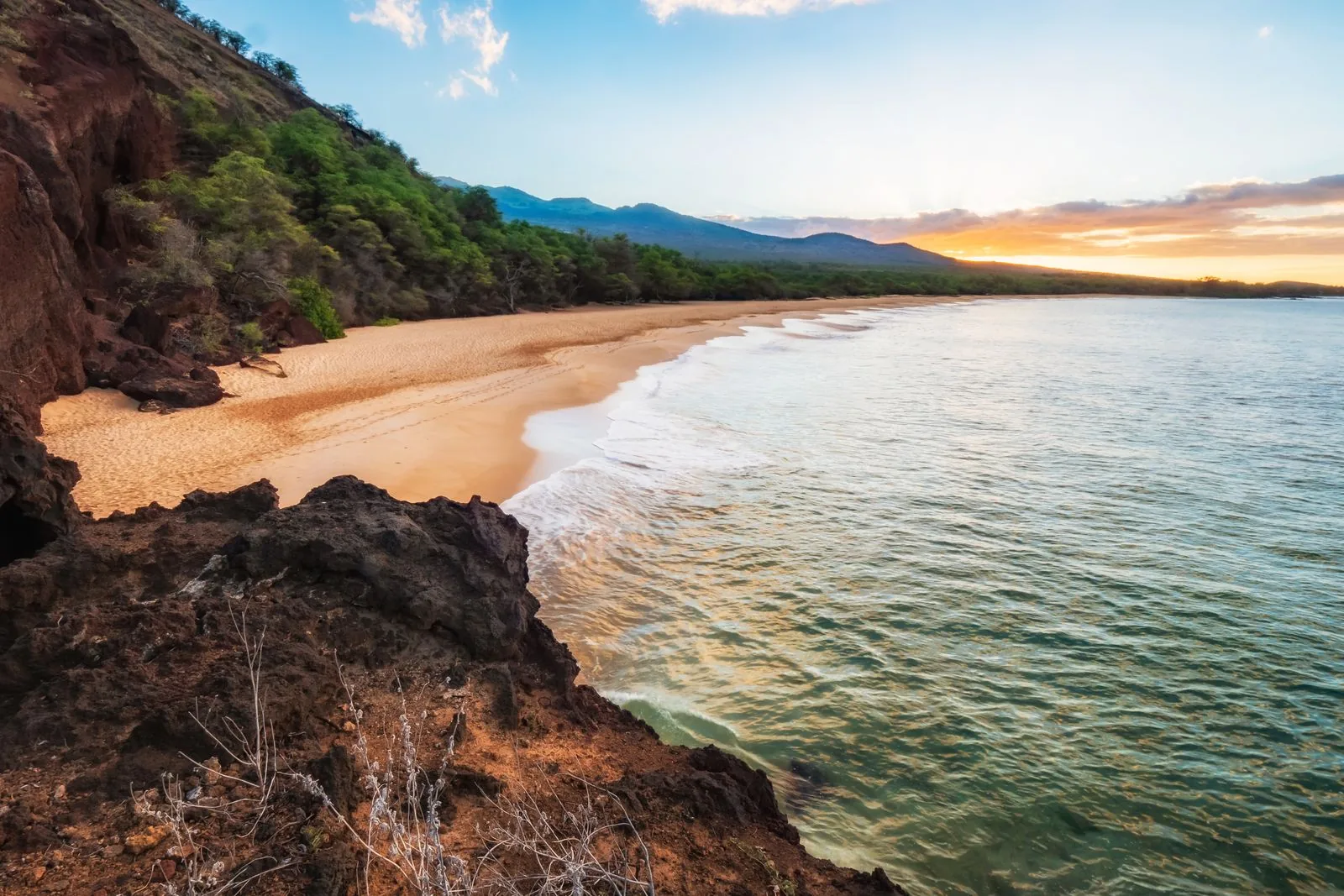 Golden-hour view of a South Maui beach cove, turquoise water meeting the mountains